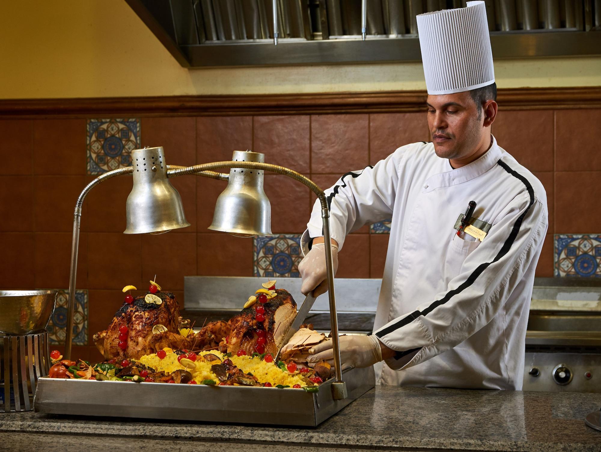 Mosaique Beach Resort Taba Heights Exterior foto A chef carving a roast